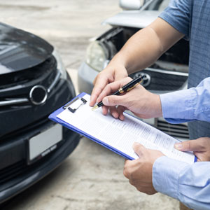 Signing paperwork after a car collision, emphasizing legal options for uninsured and underinsured drivers.